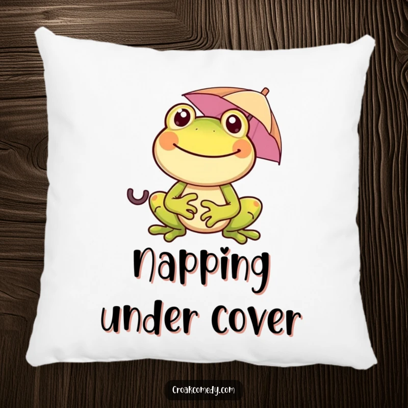 Funny, smiling frog holding a tiny umbrella, featured on a soft, decorative pillow, perfect for comfort and humor enthusiasts.