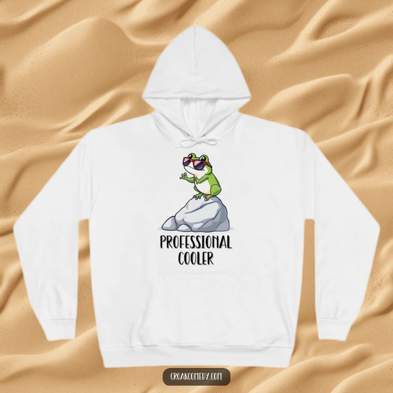 Funny frog wearing sunglasses, balanced on a rock, conveying a cool and humorous vibe on this cozy hoodie.