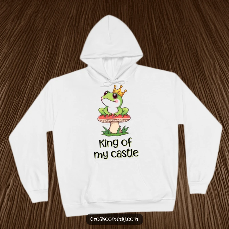 Funny Hoodie: A frog wearing a tiny crown sits regally on a mushroom, offering cozy, majestic comfort.