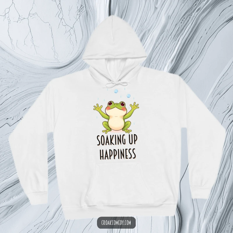 Funny hoodie depicting a small frog with arms outstretched, catching raindrops with an expression of pure delight.