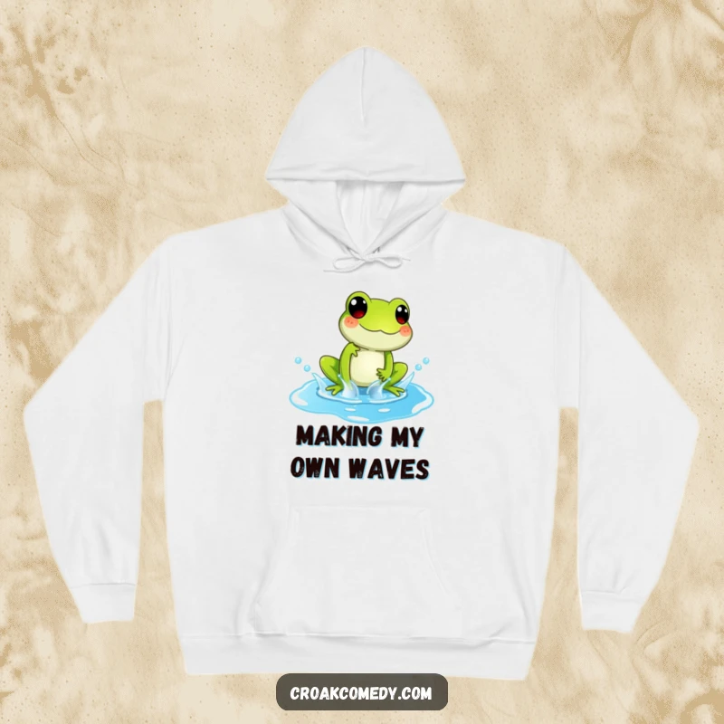 Funny Hoodie featuring a playful frog character splashing exuberantly in a bright blue puddle, symbolizing carefree joy.