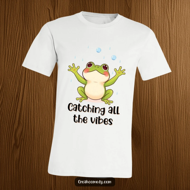 Funny t-shirt featuring a small frog with arms wide open, joyfully catching falling raindrops, celebrating weather.