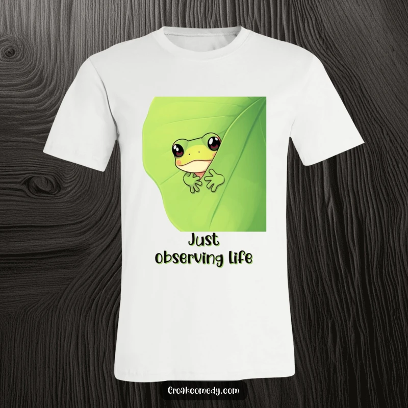 Funny curious frog peeking out from behind a vibrant green leaf, a whimsical and humorous t-shirt graphic.