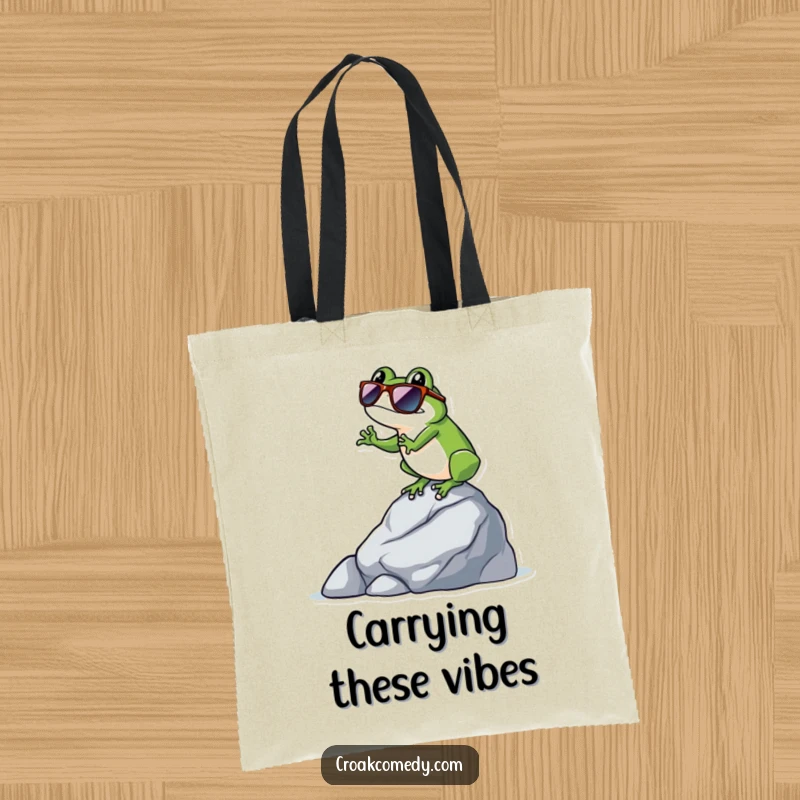 Funny frog wearing sunglasses, balancing expertly on a rock, featured on this stylish and humorous tote bag.