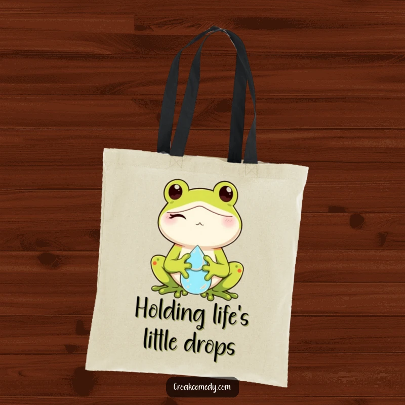 Funny tote bag featuring a winking frog character holding a glistening dewdrop, perfect for stylish and playful carrying.